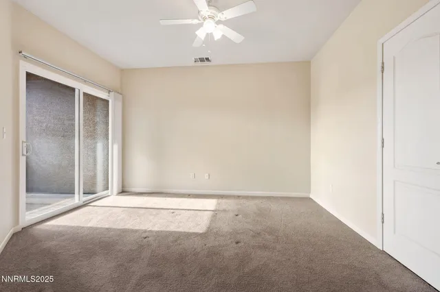 an empty room with closet and a chandelier fan