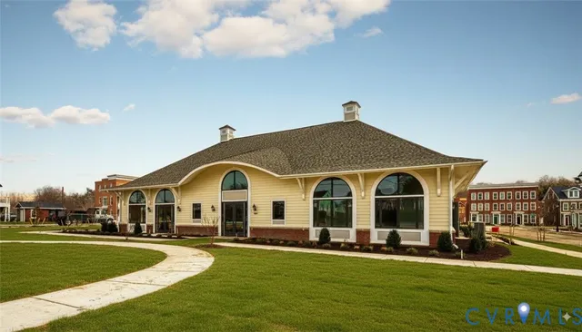 a view of a white house with a big yard and potted plants