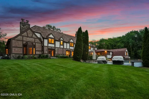 a view of a house with a big yard and large trees