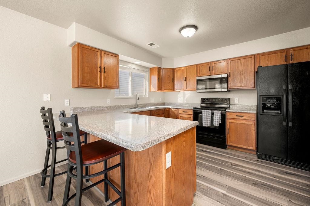 312 Catkin Street Fruita, CO 81521 - Photo 11 of 40 a kitchen with stainless steel appliances granite countertop a stove a refrigerator a sink a dining table and chairs with wooden floor