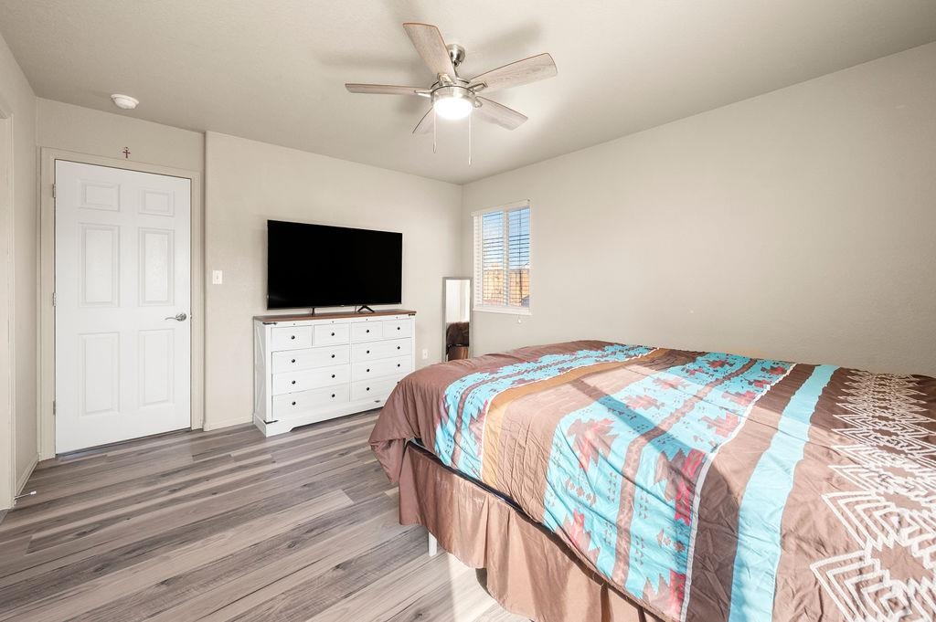 312 Catkin Street Fruita, CO 81521 - Photo 15 of 40 a bedroom with a bed and a flat tv screen on dresser