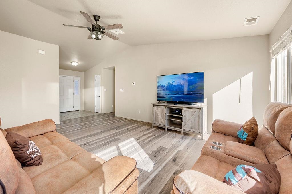 312 Catkin Street Fruita, CO 81521 - Photo 6 of 40 a spacious bedroom with a bed a couch and a chandelier