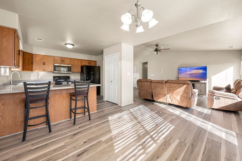 312 Catkin Street Fruita, CO 81521 - Photo 10 of 40 a view of a kitchen with kitchen island stainless steel appliances wooden floor and living room view