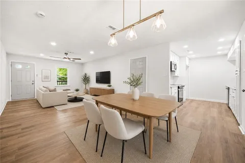 a living room with furniture a wooden floor and a chandelier