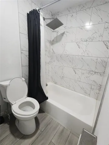 a white toilet sitting next to a bathtub