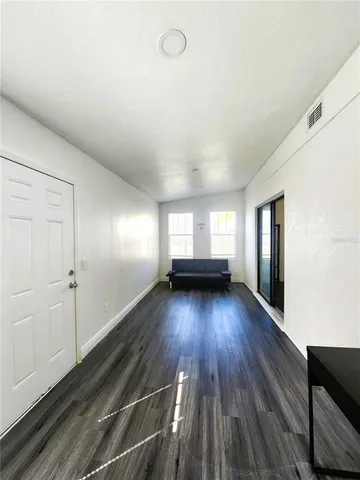 a view of empty room with wooden floor
