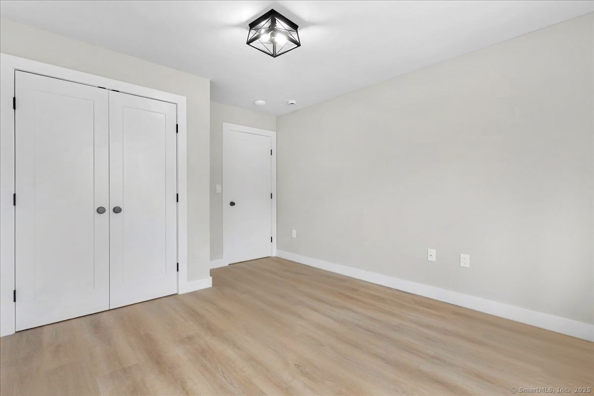 135 Gold Star Highway, Unit 410 Groton, CT 06340 - Photo 12 of 14 a view of a room with wooden floor and white doors