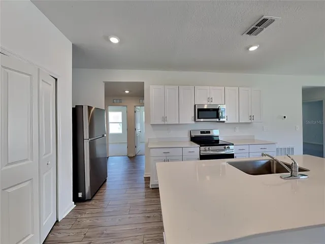 a kitchen with stainless steel appliances a refrigerator sink and cabinets