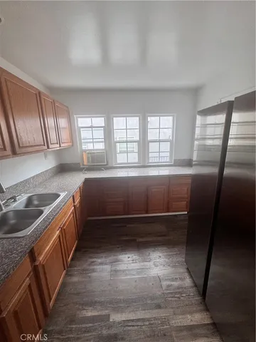 a kitchen with granite countertop a sink a counter space cabinets and stainless steel appliances