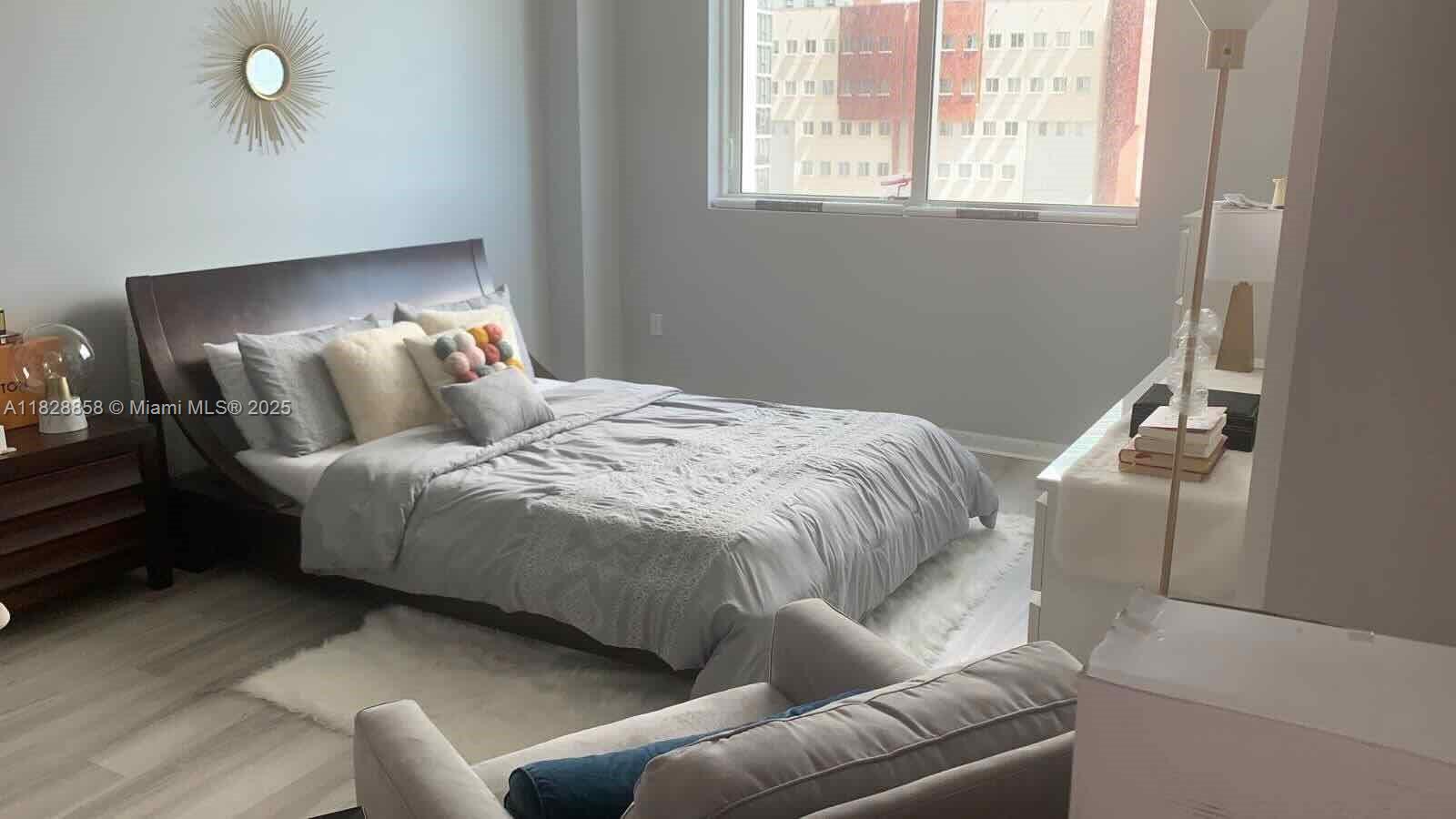 244 Biscayne Boulevard, Unit 608 Miami, FL 33132 - Photo 16 of 25 a bed room with a bed and a couch