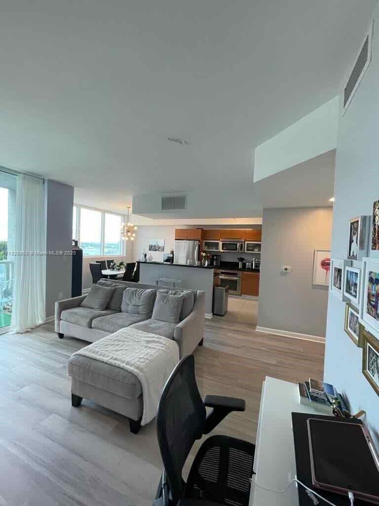 244 Biscayne Boulevard, Unit 608 Miami, FL 33132 - Photo 19 of 25 a living room with furniture and wooden floor