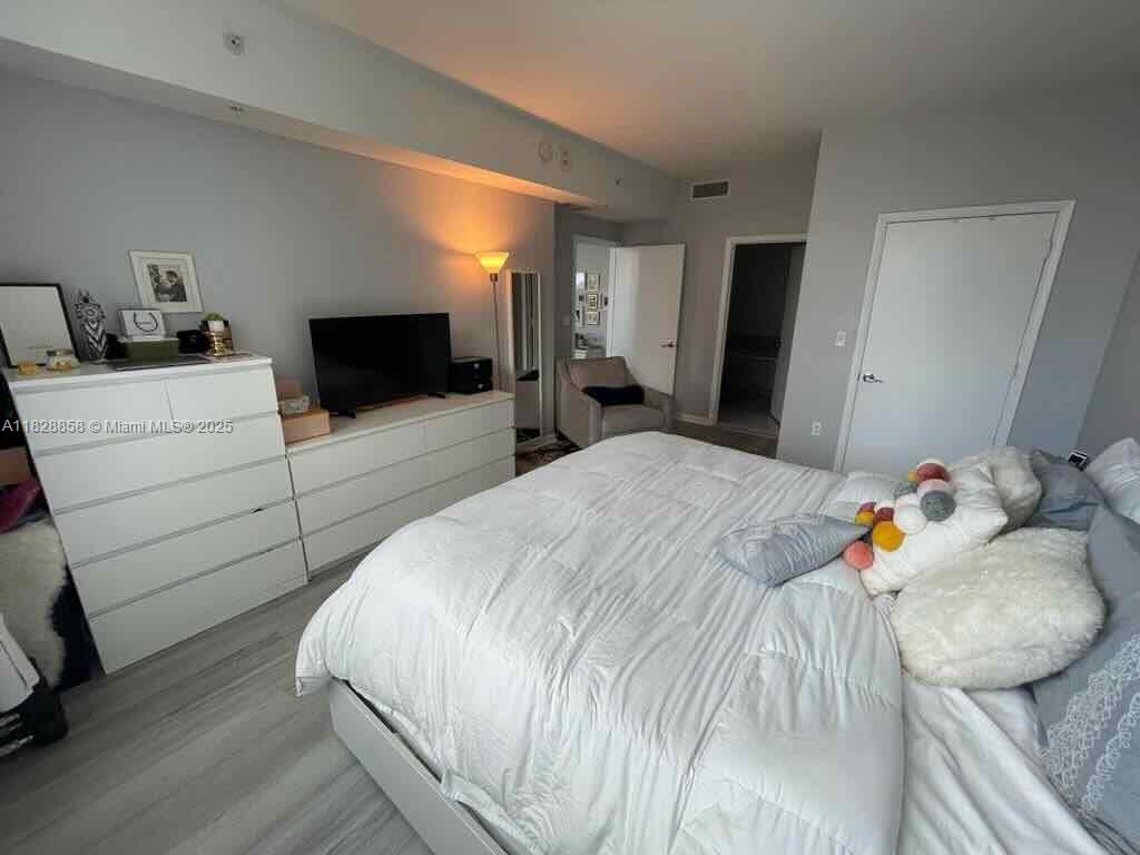 244 Biscayne Boulevard, Unit 608 Miami, FL 33132 - Photo 20 of 25 a bedroom with a bed and flat screen tv