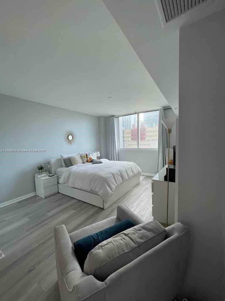 244 Biscayne Boulevard, Unit 608 Miami, FL 33132 - Photo 21 of 25 a bedroom with a bed and window