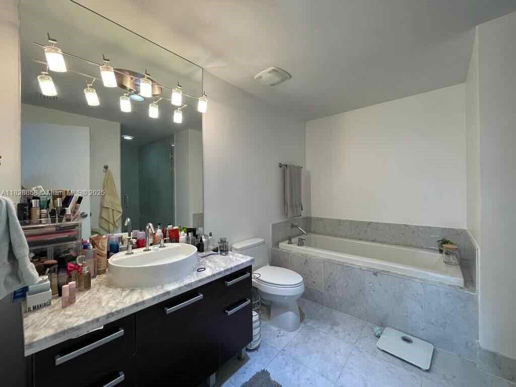244 Biscayne Boulevard, Unit 608 Miami, FL 33132 - Photo 22 of 25 a bathroom with a sink a toilet and bathtub