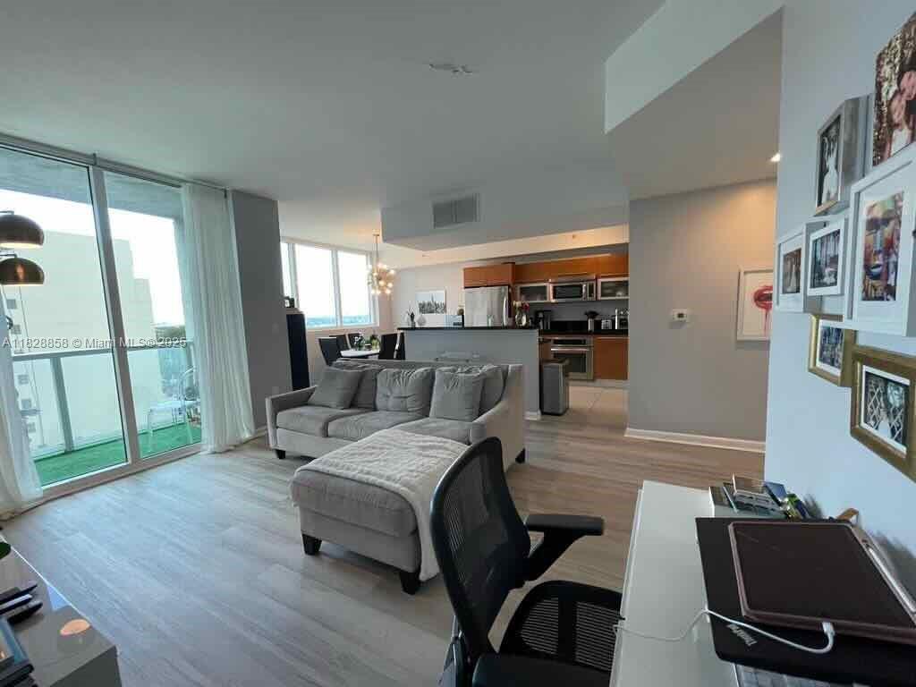 244 Biscayne Boulevard, Unit 608 Miami, FL 33132 - Photo 3 of 25 a living room with furniture and a flat screen tv