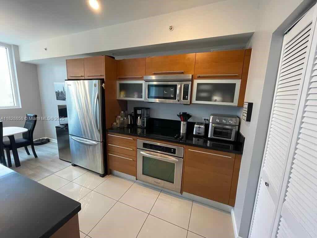 244 Biscayne Boulevard, Unit 608 Miami, FL 33132 - Photo 4 of 25 a kitchen with stainless steel appliances granite countertop a refrigerator and a stove top oven