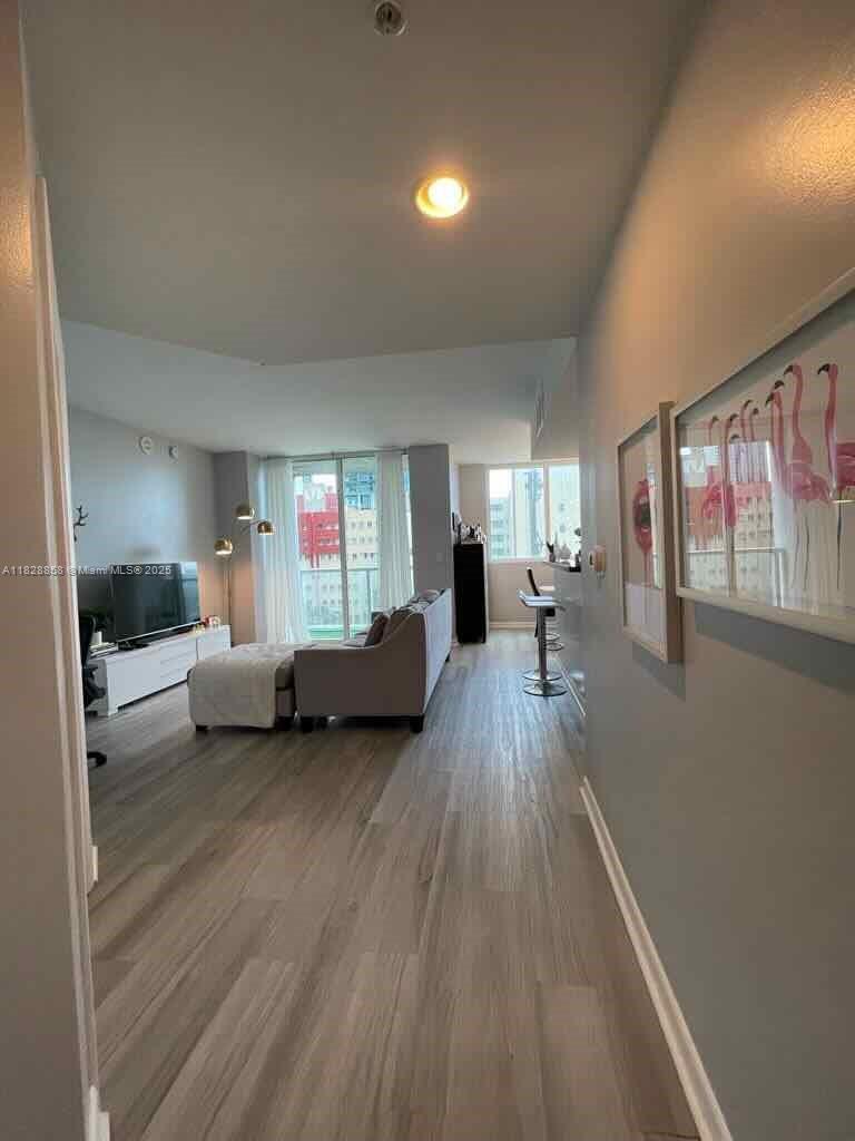 244 Biscayne Boulevard, Unit 608 Miami, FL 33132 - Photo 7 of 25 a living room with furniture and a wooden floor