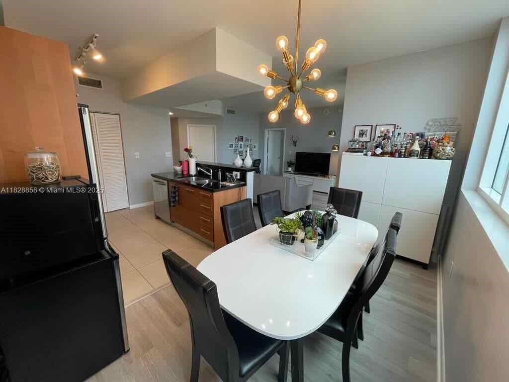 244 Biscayne Boulevard, Unit 608 Miami, FL 33132 - Photo 10 of 25 a view of a dining room with furniture and wooden floor