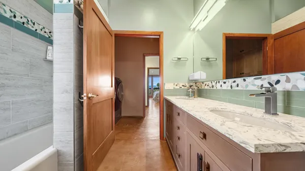 a bathroom with a granite countertop sink and a mirror