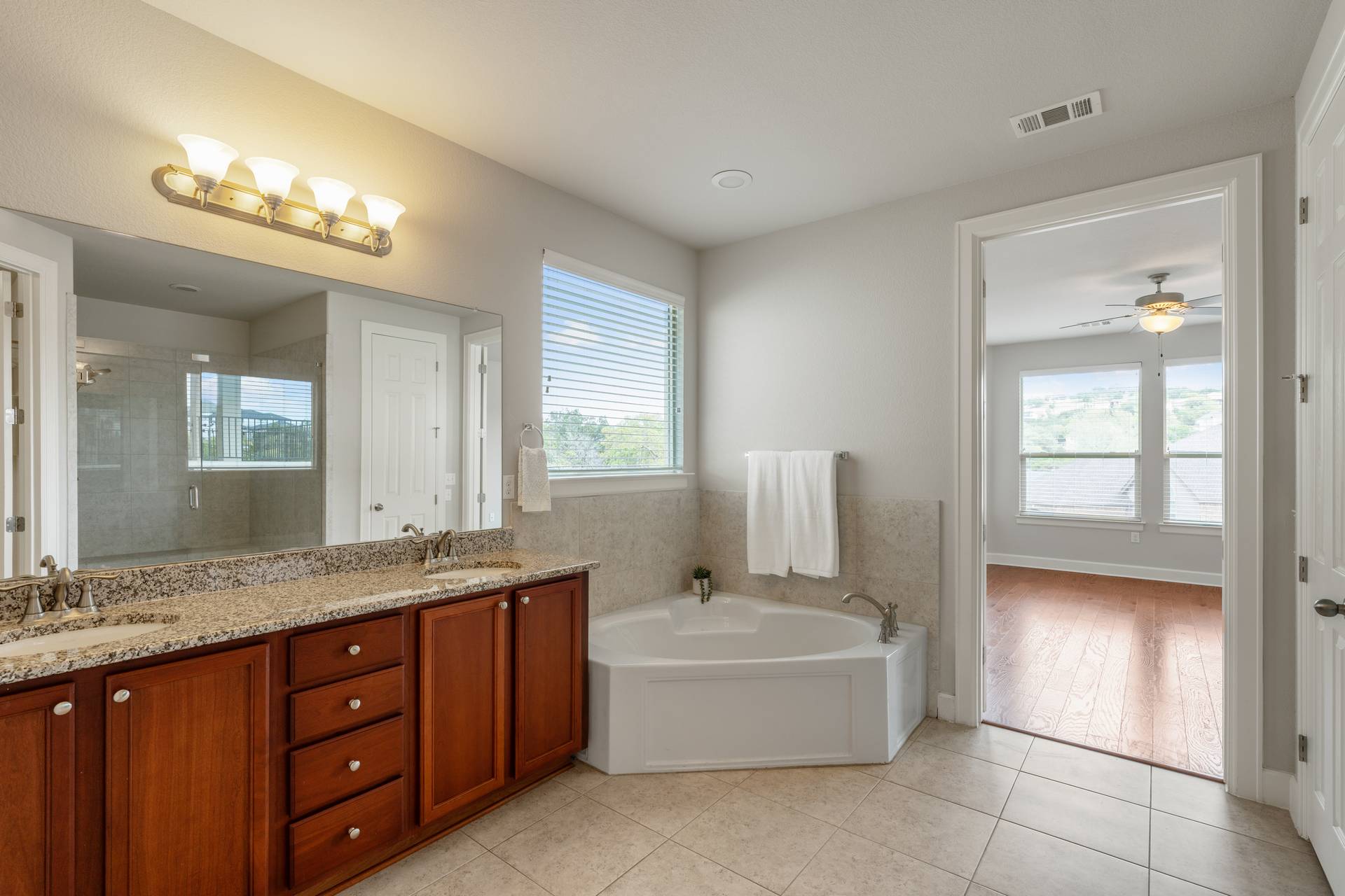 3516 Venezia View Leander, TX 78641 - Photo 10 of 40 Bathroom featuring double vanity, light tile patterned floors, healthy amount of natural light, and a garden tub