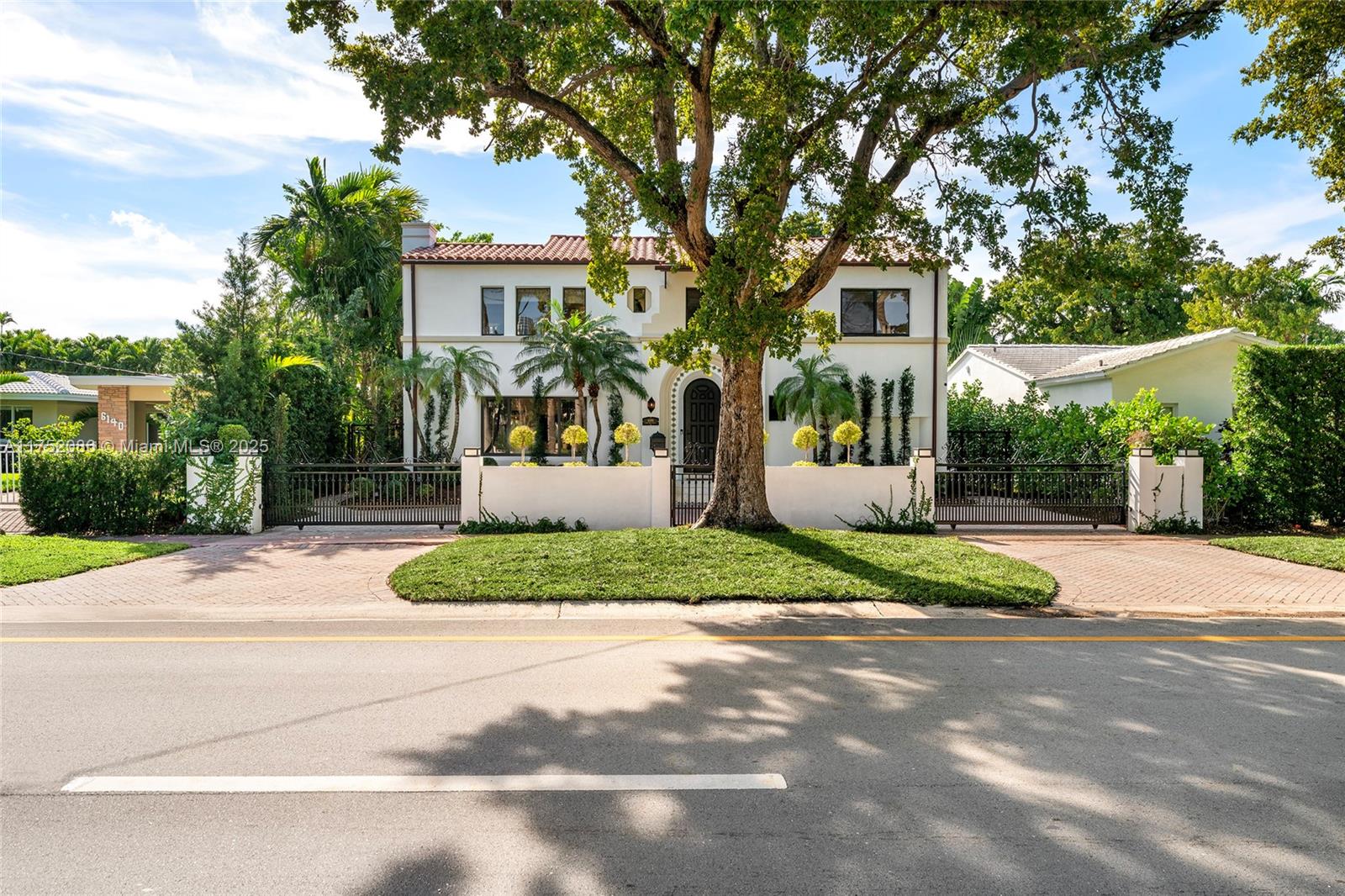 a front view of a house with a yard and potted plants