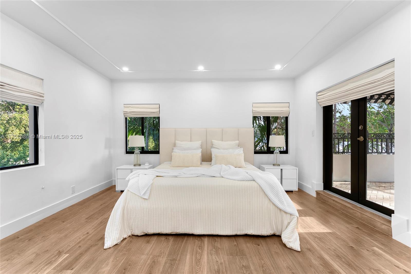 6146 Pine Tree Drive Miami Beach, FL 33140 - Photo 12 of 30 a spacious bedroom with a large bed and wooden floor