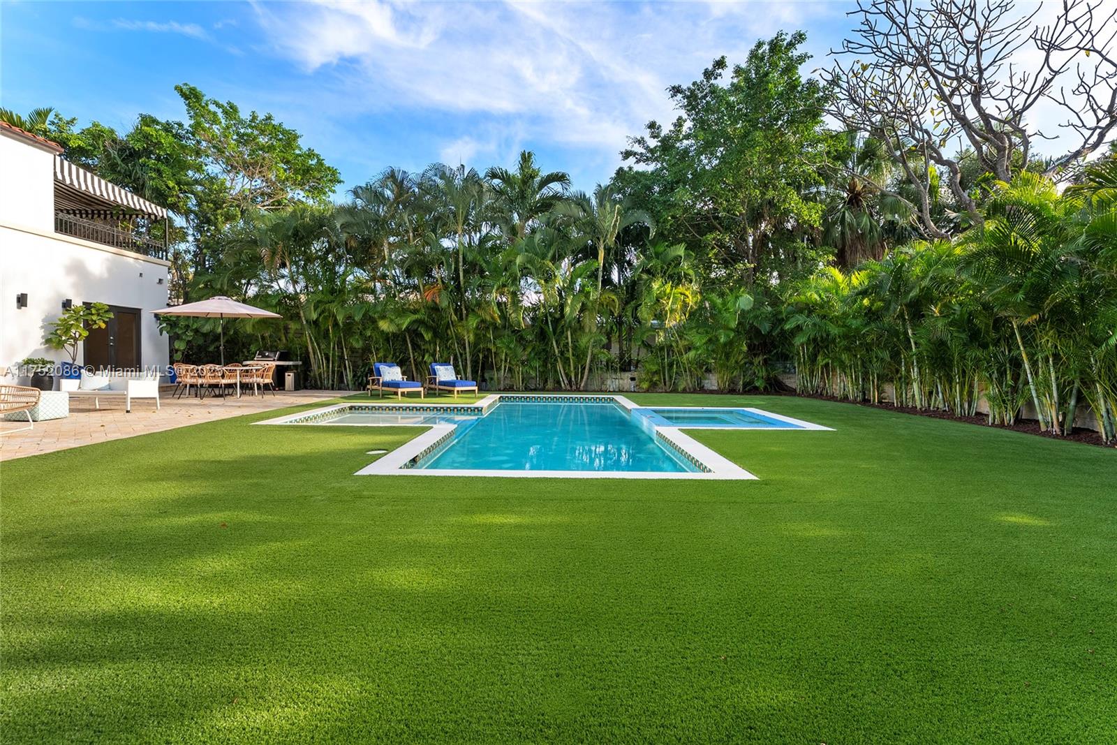 6146 Pine Tree Drive Miami Beach, FL 33140 - Photo 27 of 30 a view of a swimming pool with lawn chairs under an umbrella