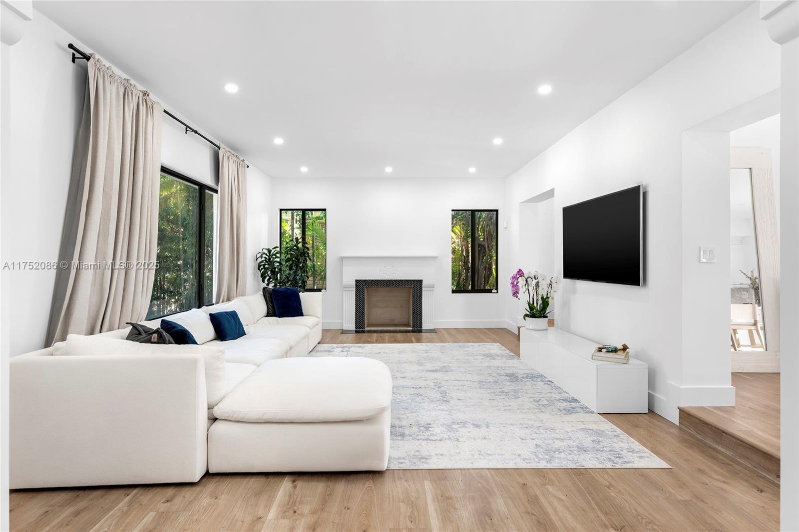 6146 Pine Tree Drive Miami Beach, FL 33140 - Photo 10 of 30 a living room with furniture a flat screen tv and a fireplace