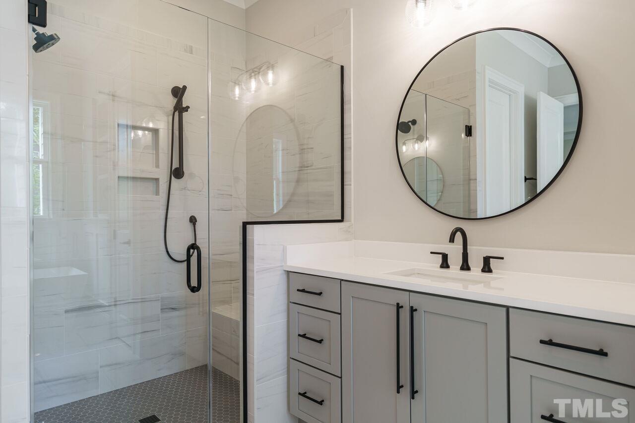 2609 Sanctuary Wds Lane Raleigh, NC 27606 - Photo 17 of 38 a bathroom with a sink a mirror a vanity and a shower