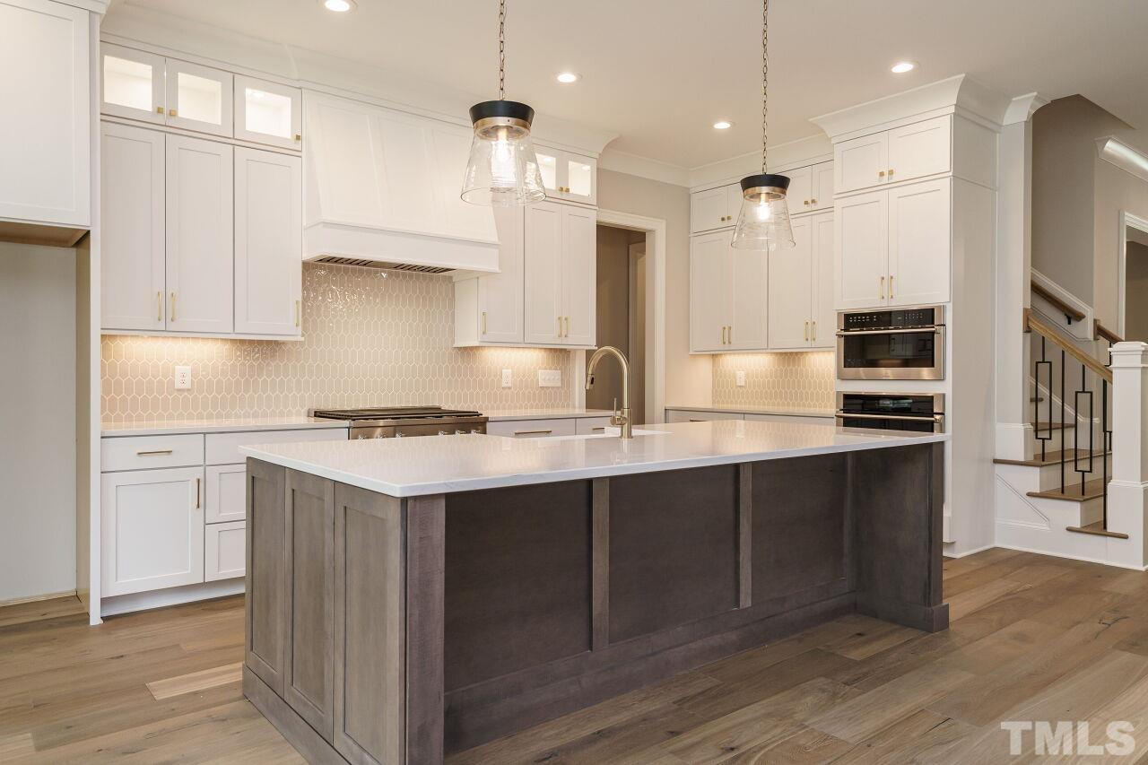 2609 Sanctuary Wds Lane Raleigh, NC 27606 - Photo 3 of 38 a kitchen with stainless steel appliances granite countertop a sink a stove a refrigerator and island with wooden floor