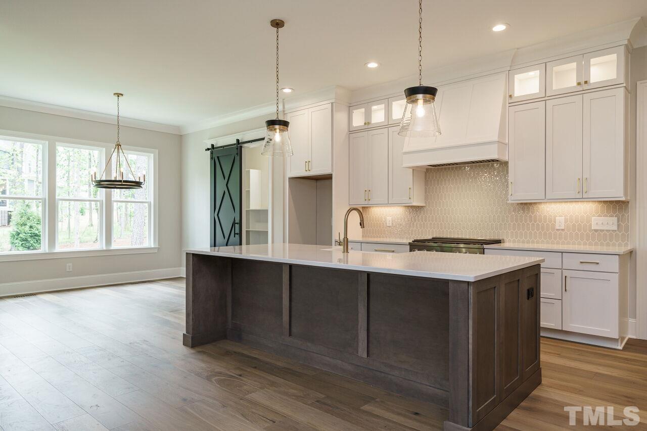 2609 Sanctuary Wds Lane Raleigh, NC 27606 - Photo 5 of 38 a kitchen with stainless steel appliances granite countertop a sink a stove and a wooden floor
