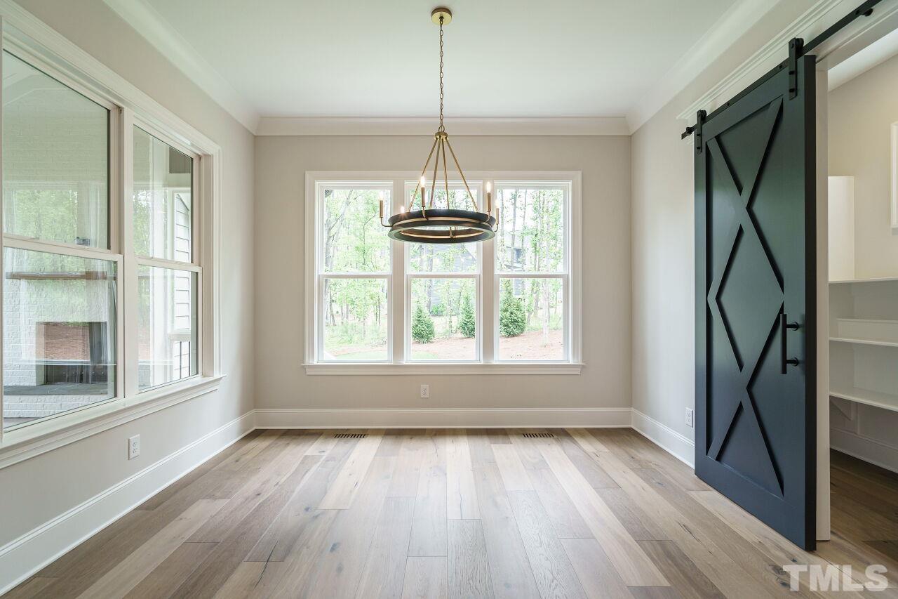 2609 Sanctuary Wds Lane Raleigh, NC 27606 - Photo 7 of 38 a view of an empty room with wooden floor and a window