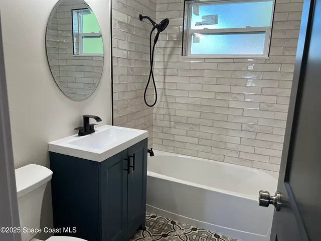 a bathroom with a sink vanity mirror and tub