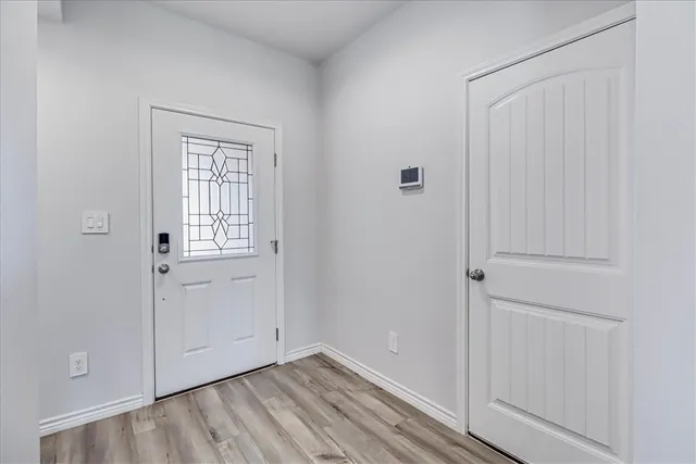 a view of an empty room with closet and a window