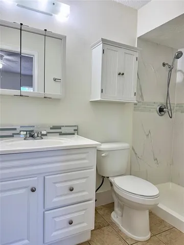 a bathroom with a toilet a sink a vanity and mirror