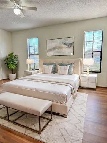a bedroom with a large bed a mirror and windows