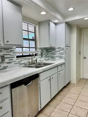 a kitchen with stainless steel appliances granite countertop a sink and a white cabinets