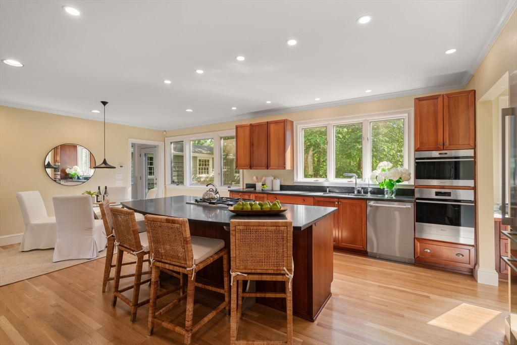 15 Training Field Road Wayland, MA 01778 - Photo 14 of 37 a kitchen with stainless steel appliances granite countertop wooden cabinets a stove top oven a sink with dining table and chairs