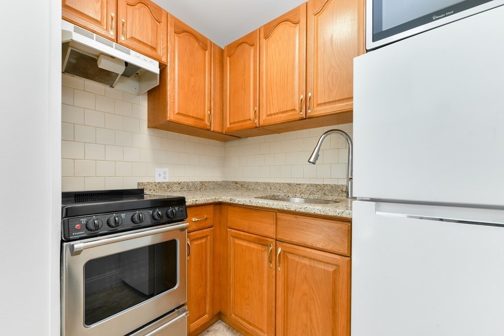 36 Winchester Street, Unit 2 Brookline, MA 02446 - Photo 6 of 18 a kitchen with granite countertop cabinets stainless steel appliances and a counter space