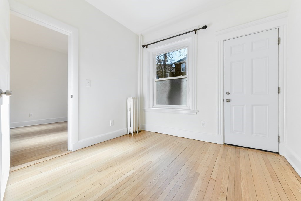 36 Winchester Street, Unit 2 Brookline, MA 02446 - Photo 7 of 18 an empty room with wooden floor and windows