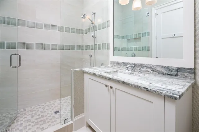 a bathroom with a granite countertop sink a shower and a mirror