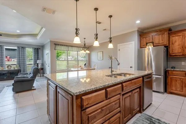 a kitchen with granite countertop a sink a counter top space appliances and cabinets