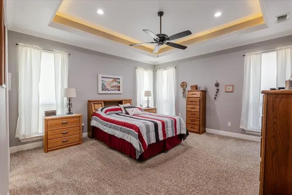 a spacious bedroom with a bed and a chandelier