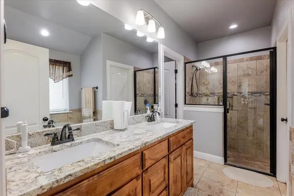 a bathroom with a granite countertop sink mirror and shower