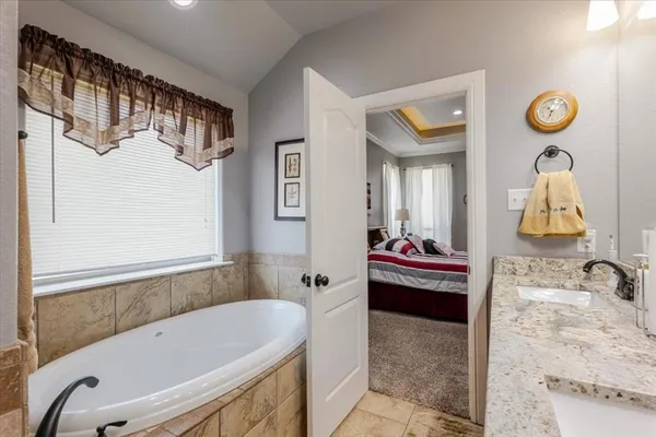 a bathroom with a tub sink and mirror