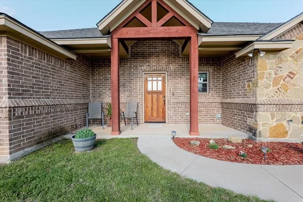 a front view of a house with a yard and seating space