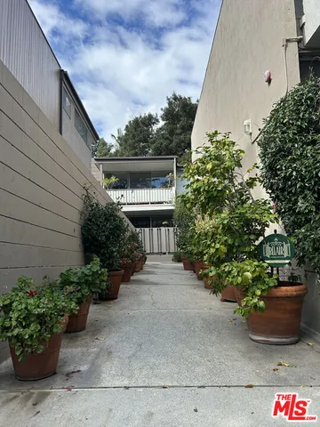 a front view of a house with a yard and potted plants