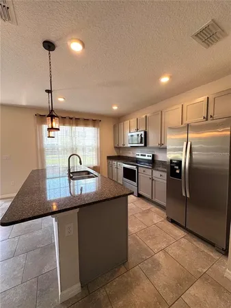 a kitchen with stainless steel appliances granite countertop a sink counter space cabinets and a counter top space