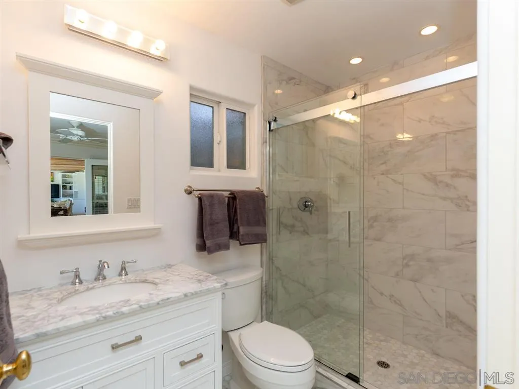 5486 Soledad Road La Jolla, CA 92037 - Photo 17 of 25 a bathroom with a granite countertop sink a toilet and shower