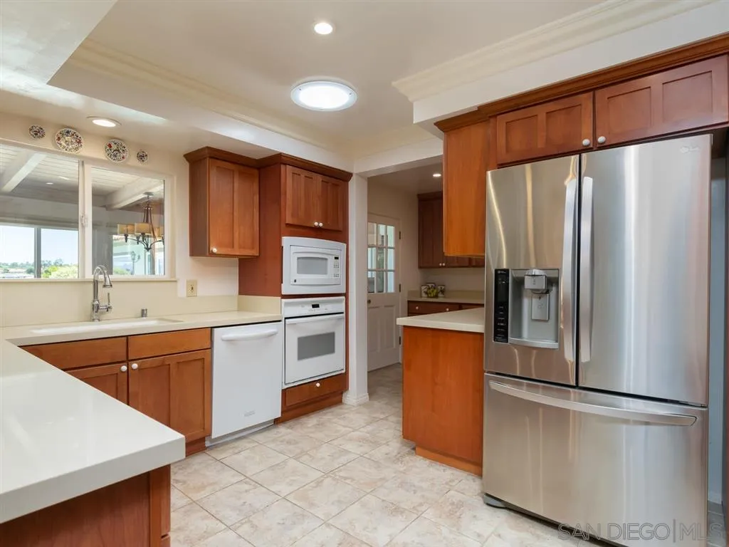 5486 Soledad Road La Jolla, CA 92037 - Photo 9 of 25 a kitchen with stainless steel appliances a refrigerator sink and microwave
